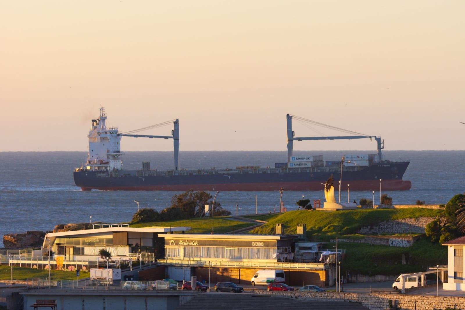Buque de carga saliendo, visto desde la costa.